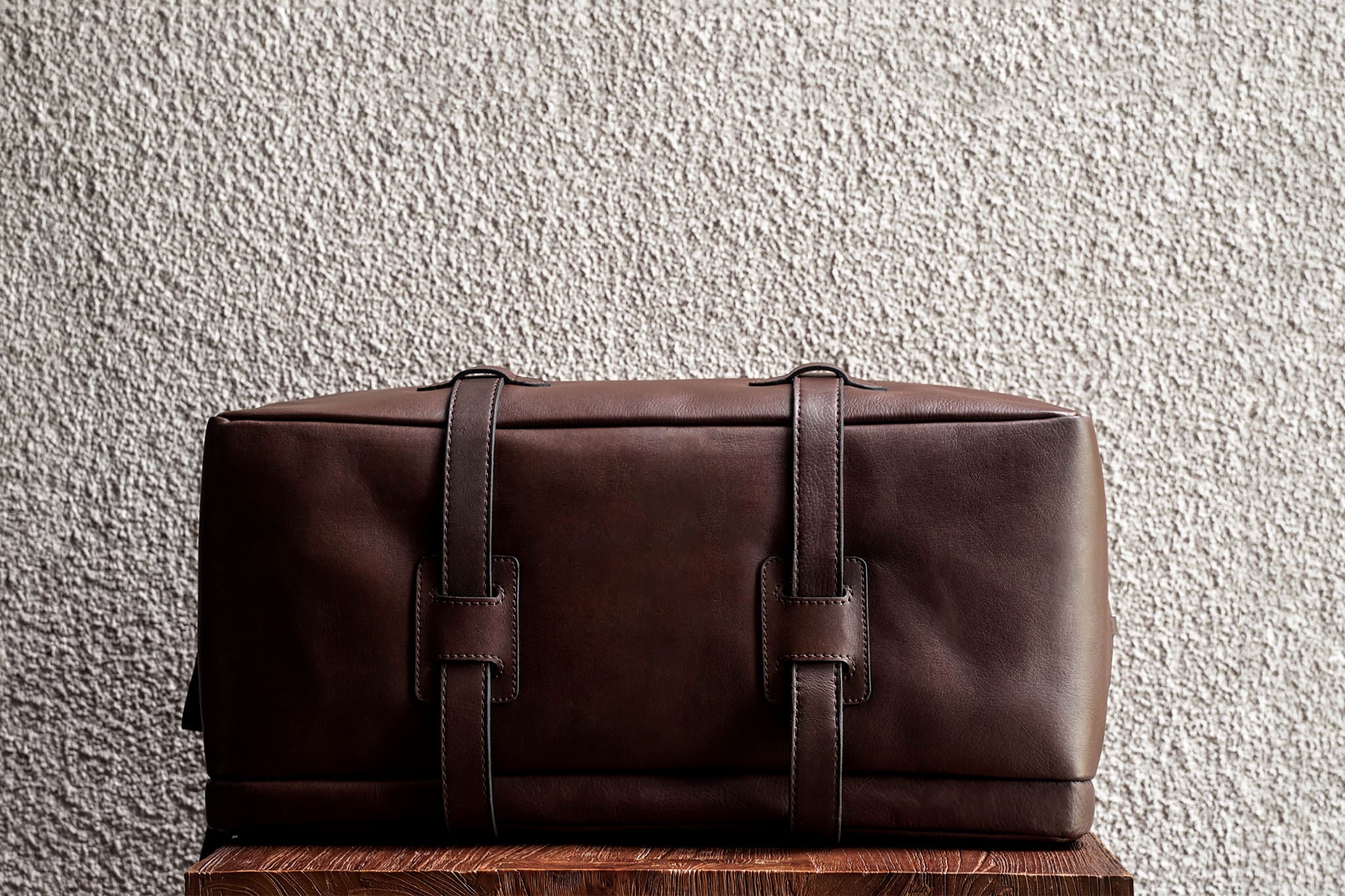 One of our signature design cues, the body straps go all around the bag, providing a load bearing structure for the bag. A big piece of leather on the bottom adds to the durability of the bag.