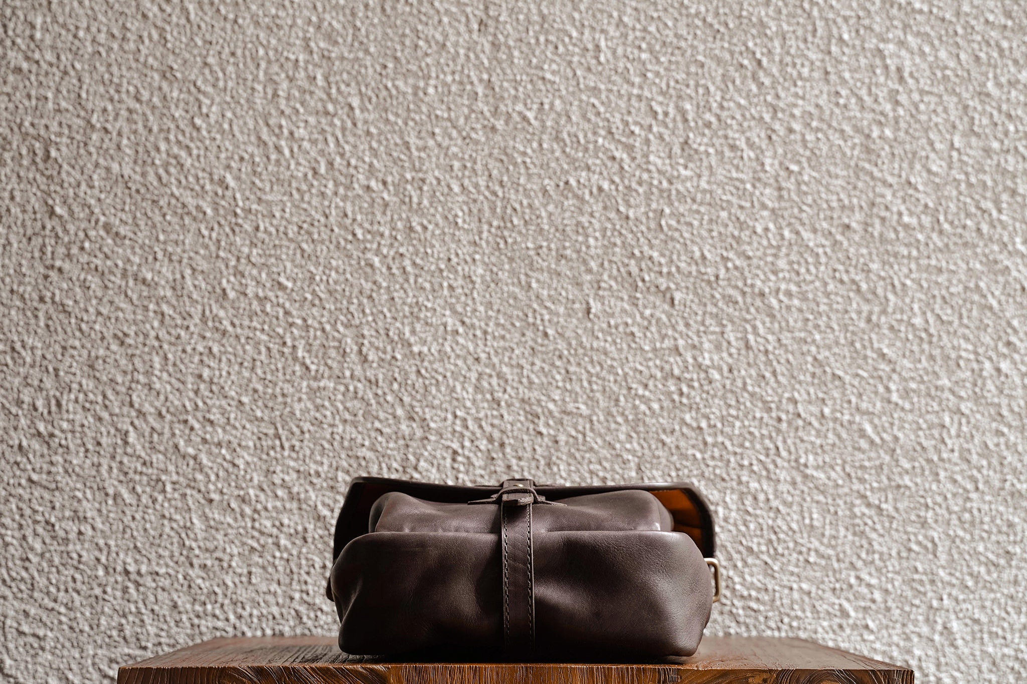 One of our signature design cues, the body strap goes all around the bag, providing a load bearing structure for the bag. Keeping with the goal to minimize seams, the sides and bottom are made from one big piece of leather.
