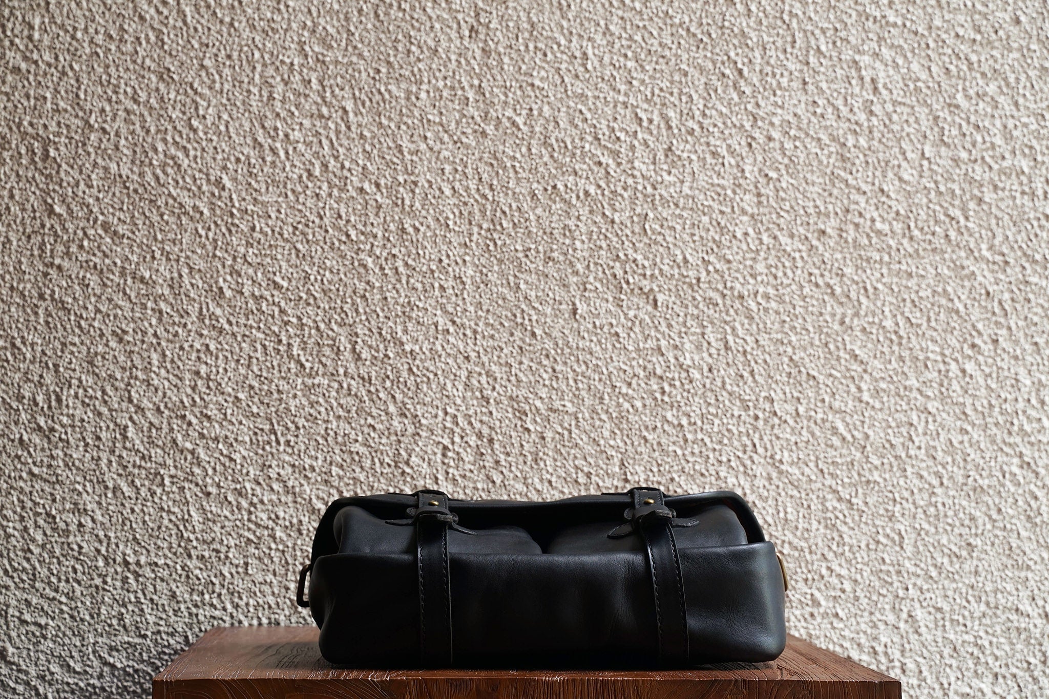 One of our signature design cues, the body straps go all around the bag, providing a load bearing structure for the bag. Keeping with the goal to minimize seams, the sides and bottom are made from one big piece of leather.
